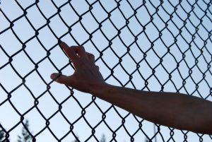 Leaning against a chain link fence during a sport